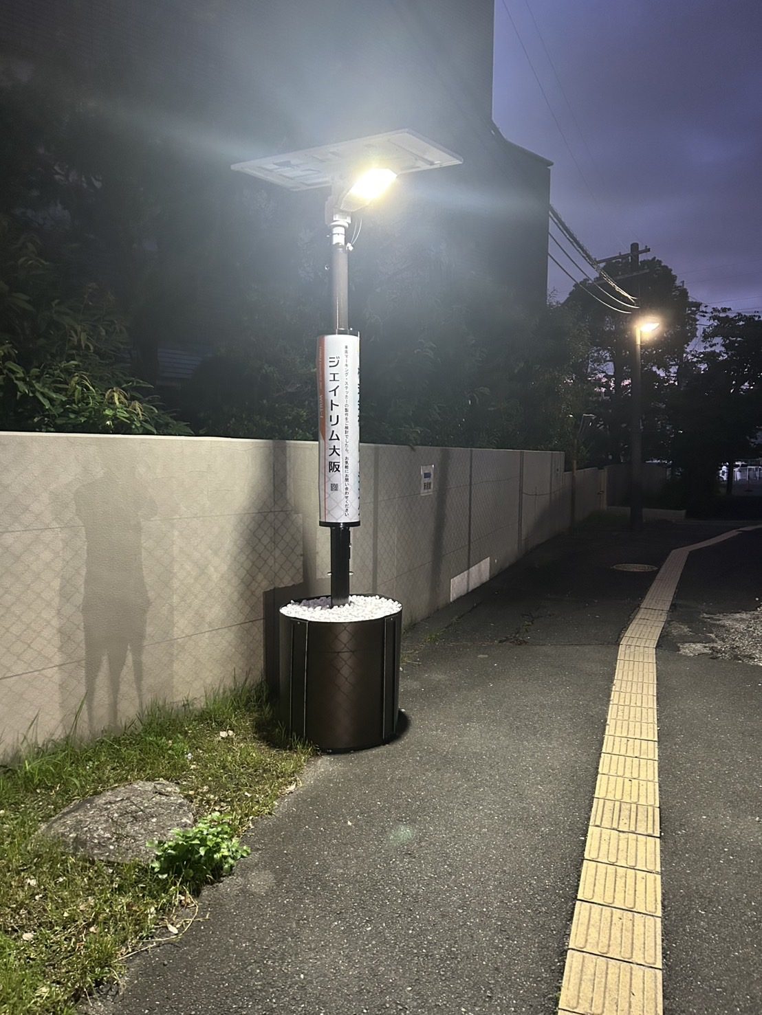 企業の広告を掲げて夜道を照らすライト